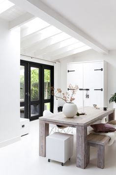 a dining room table with two chairs and a vase on it