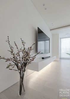 a vase filled with flowers sitting on top of a white floor next to a tv