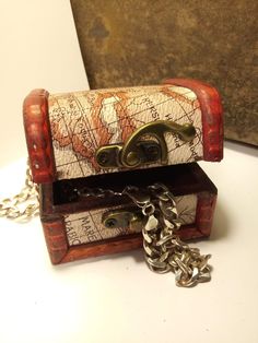 a small wooden box with a map on it and a chain hanging from the front