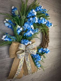 a wreath with blue and white flowers hanging on a wall