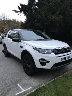 a white land rover parked in a parking lot