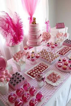 a table topped with lots of pink desserts