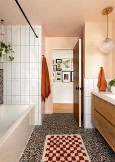 a bath room with a rug a sink and a bath tub next to each other