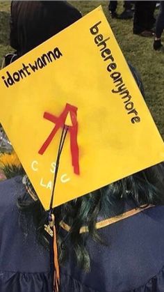 a yellow sign sitting on the back of a person's head with red ribbon