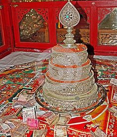 an elaborately decorated cake on display in a room with red walls and ornate decorations