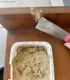 someone using a knife to cut through the top of a cake pan with dirt on it