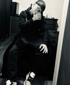 a man taking a selfie in the mirror with his cell phone and shoes on