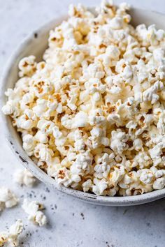 a white bowl filled with popcorn on top of a table