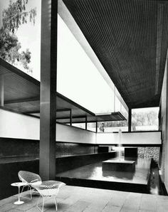 a black and white photo of a bench in front of a building with large windows