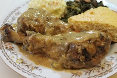 a white plate topped with meat covered in gravy