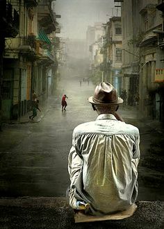 a man sitting on top of a skateboard in the middle of an alley way