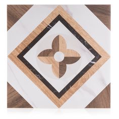 a white and brown tile with an abstract flower design on it's center piece