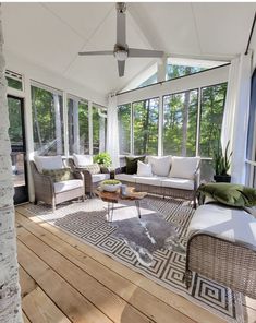 a sun room with couches, tables and windows