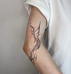 a woman's arm with a tattoo on it that has vines growing out of it