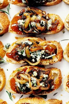 many different types of breads with cheese and toppings on them sitting on a white surface