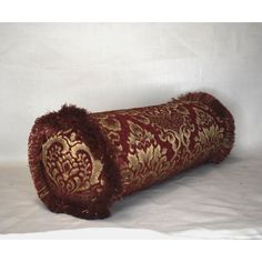 a red and gold decorative pillow on a white background