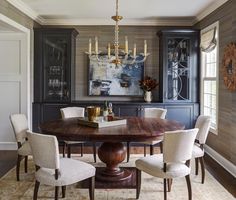 a dining room table with chairs around it and a chandelier hanging from the ceiling