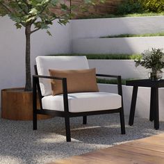 a white chair sitting next to a small table with a potted tree on it