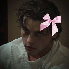 a young man with a pink bow on his head