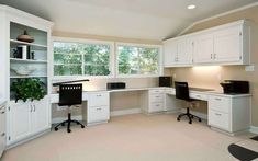 an empty office with white cabinets and black desks in the middle of the room