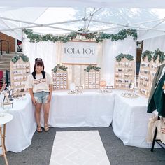 a woman standing in front of a table with lots of items on it