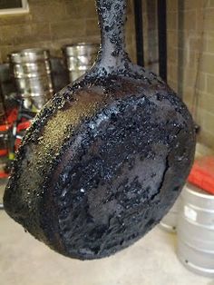 a large piece of burnt metal hanging from a hook in a room filled with cans