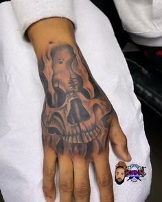 a hand with a skull tattoo on it