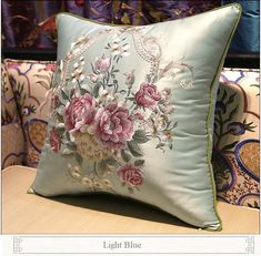 a blue pillow with pink flowers on it