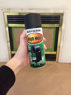 a person holding a can of high heat insect repellent in front of a fireplace