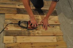 a person is working on some wood planks