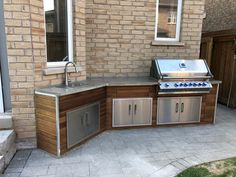 an outdoor kitchen with stainless steel and wood