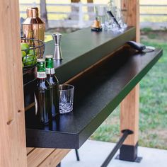 an outdoor bar with bottles and glasses on it