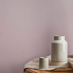 a white vase sitting on top of a wooden table