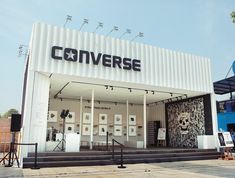 a white building with black lettering on the side and stairs leading up to it's entrance