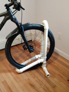 there is a bike that has been placed on the floor with pipes attached to it