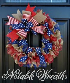 a patriotic wreath with red, white and blue ribbons on it is hanging from the front door