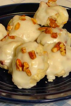 some kind of food that is sitting on a black plate with white icing and nuts