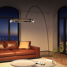 a living room with a couch, coffee table and large window overlooking the city at night