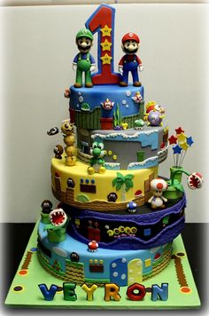 a birthday cake is decorated with mario and luigi's number one on the top