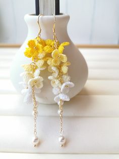 yellow and white crocheted flowers are hanging from gold - plated chain earrings