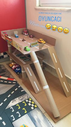 a toy table with cars on it in a playroom for children to play together