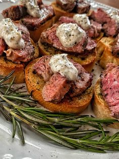 a plate topped with meat and bread on top of a table