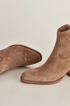 The western boot is back. SILMA is the best of both worlds, with a mid-calf design that complements fall prairie dresses and well-worn denim alike. In short? She's ready for all this season's best outfits. 100% Bovine Suede Upper Synthetic Outsole Microsuede Lining 5.7" Shaft Height 2.2" Heel Height Runs true to size FINAL SALE Cowgirl Ankle Boots, Prairie Dresses, Ankle Cowboy Boots, Trending Sandals, Western Booties, Suede Fashion, Best Of Both Worlds, Best Outfits, Brown Heels