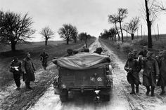 an old black and white photo of people walking on a dirt road