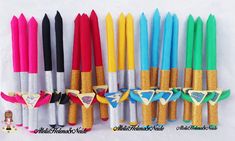 several different colored pens lined up next to each other on a white surface with gold trim