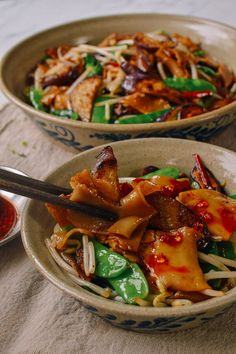 two bowls filled with food on top of a table