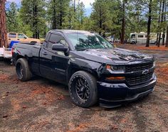 a black truck is parked in the woods