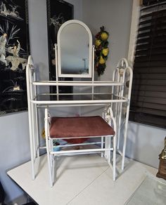 a white dressing table with mirror and stool