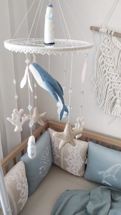 a baby crib with a blue and white mobile hanging from it's side