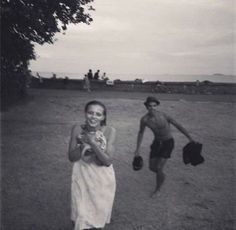 black and white photograph of two people playing baseball in an open field with one holding a ball